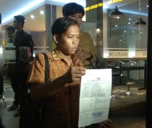 AR yang menjadi korban dugaan penganiayaan oleh seorang pilot menunjukkan surat laporannya ke Polrestabes Surabaya. Foto: Istimewa.