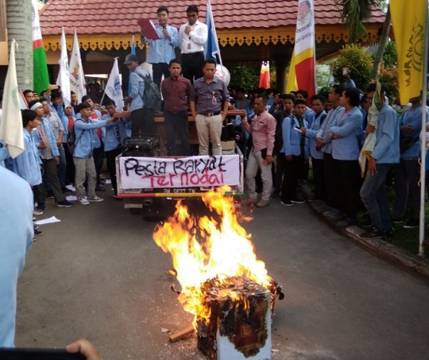 Mahasiswa UNRI membakar replika kotak suara sebagai bentuk protes pelaksanaan Pemilu 2019 di halaman Kantor KPU Riau. Foto: Surya/Riau1.