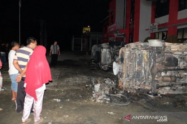 Warga melihat bangkai mobil bekas kebakaran di Lapas Langkat, Sumatera Utara, Jumat. 
