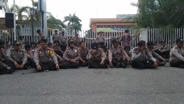 Kapolresta Pekanbaru, Kombes Pol Susanto mengajak para personelnya duduk bersila di depan gerbang Kantor KPU Riau dalam mengawal Aksi Super Damai (foto: barkah/riau1.com)