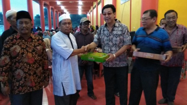 Locu Kwan Tee Kong Bio, Armanto (kanan) menyerahkan paket lebaran kepada warga RW 009 (foto: barkah/riau1.com)