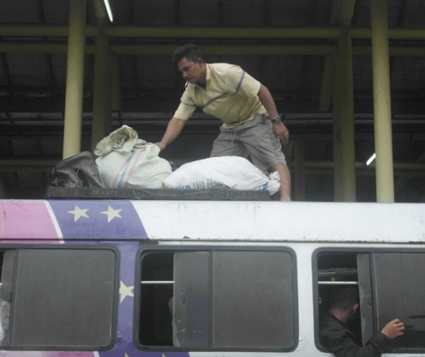 Sopir bus Antar Kota Dalam Provinsi (AKDP) sedang mengatur barang penumpang di Terminal BRPS Pekanbaru, Rabu (12/6/2019). Foto: Surya/Riau1.