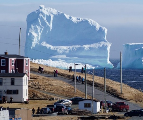 Warga melihat bongkahan es raksasa yang bergerak melewati perairan Ferryland Newfoundland, Kanada, 16 April 2017. Foto: Reuters. 