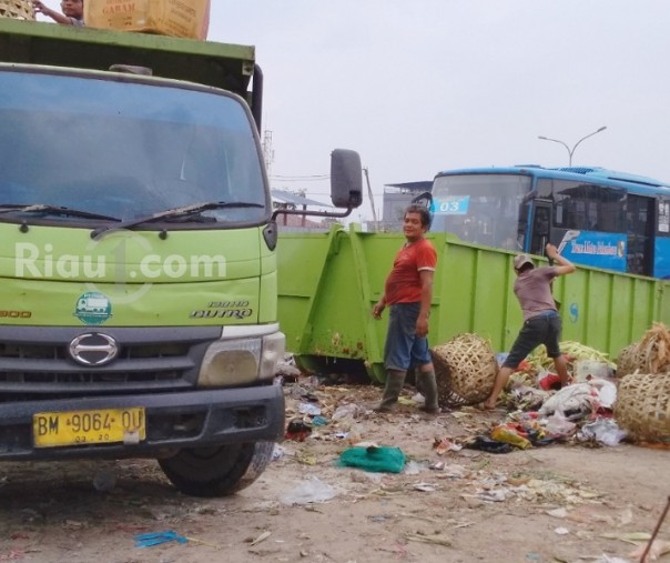 Pekerja sedang mengangkut sampah di Pasar Pagi Arengka (Foto:Zar/Riau1.com)
