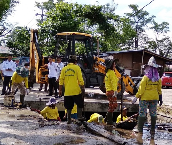 Para pekerja Dinas PUPR Pekanbaru sedang membersihkan drainase di Jalan Arifin Ahmad, beberapa waktu lalu. Foto: Surya/Riau1.