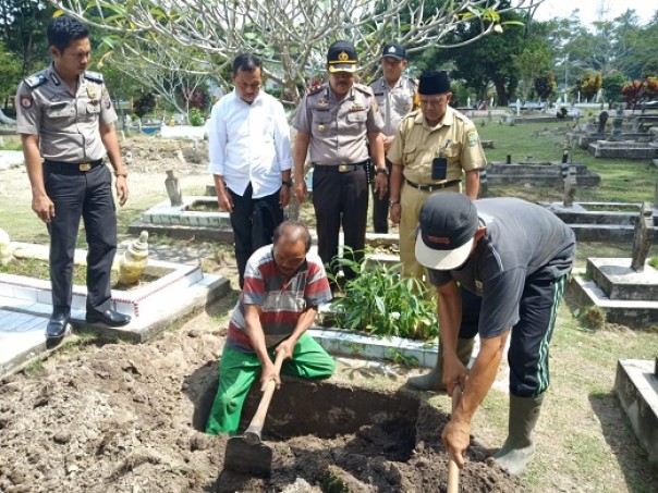 Kapolsek Siak, Kompol Abdul Rahman saat menyaksikan proses pemakaman bayi malang yang ditemukan warga Kampung Dalam, Siak (foto: rizal/riau1.com)