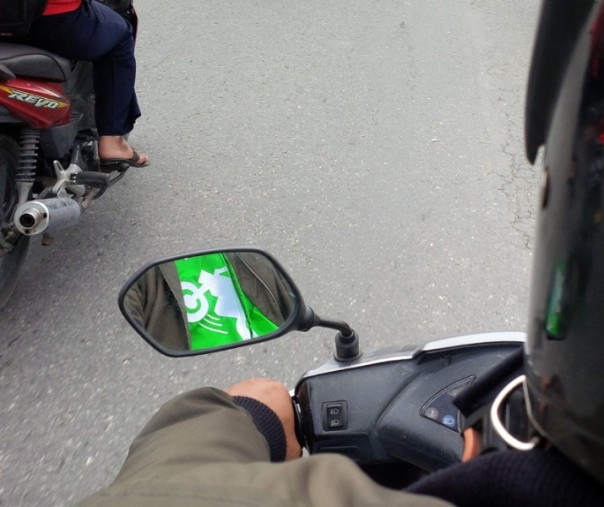 Pengemudi ojek online yang mengenakan baju Gojek (Foto: Zar/Riau1.com)