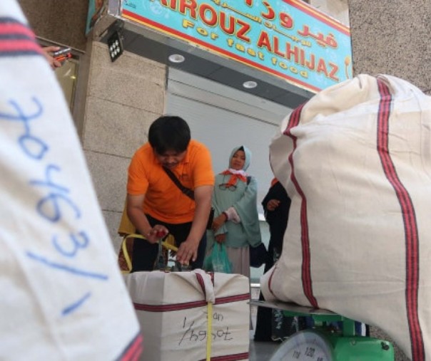 Petugas mengepak barang belanjaan jemaah haji untuk dikirim ke Indonesia di Madinah, Sabtu (13/7/2019). Foto: Media Center Haji. 