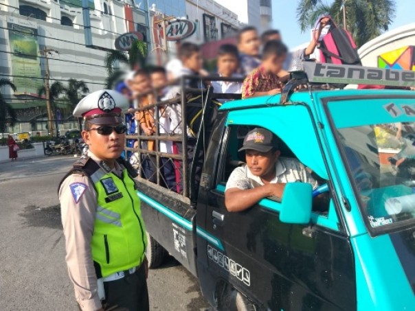 Personel Satlantas Polresta Pekanbaru menertibkan mobil bak terbuka yang angkut puluhan anak-anak