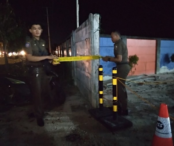 Petugas Satpol PP Pekanbaru saat memasang garis dilarang masuk ke MBC Hotel, Selasa (7/7/2019).