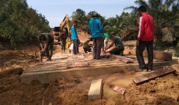 TNI bersama warga Desa Balung membangun jembatan di Dusun V, Sei Asam, Kampar