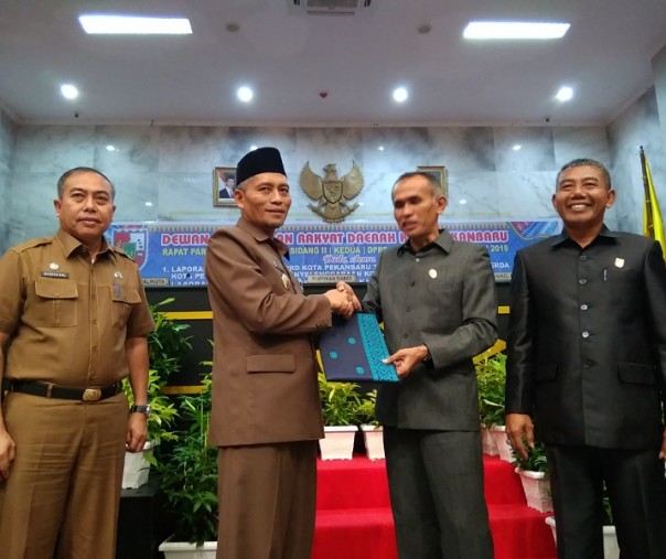 Wakil Wali Kota Pekanbaru Ayat Cahyadi (dua dari kiri) menerima Perda Kota Layak Anak yang sudah disahkan dari Wakil Ketua DPRD Pekanbaru Nofrizal, Senin (22/7/2019). Foto: Surya/Riau1.