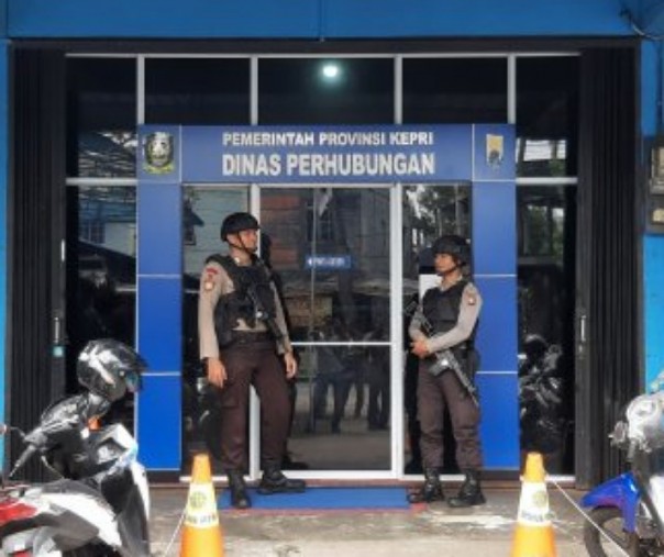KPK geledah kantor Dishub Kepri, tampak beberapa anggota polisi sedang berjaga di depan kantor tersebut. Foto: Antara. 