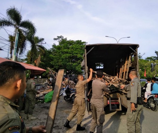Petugas Satpol PP Pekanbaru saat menertibkan lapak pedagang kali lima Jalan Soebrantas Panam. Foto: Surya/Riau1.
