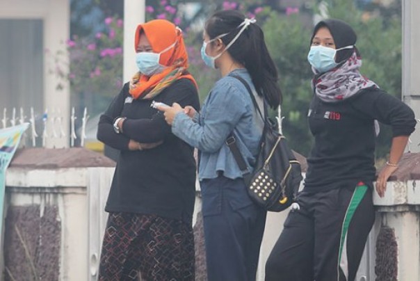 Ilustrasi warga mengenakan masker akibat akbut asap