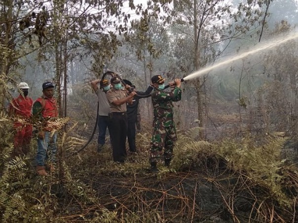 Tim Damkar PT SRL, BPBD Inhil, TNI dan Polri serta masyarakat bersama-sama melakukan pemadaman Karlahut di Desa Kerta Jaya Kecamatan Kempas