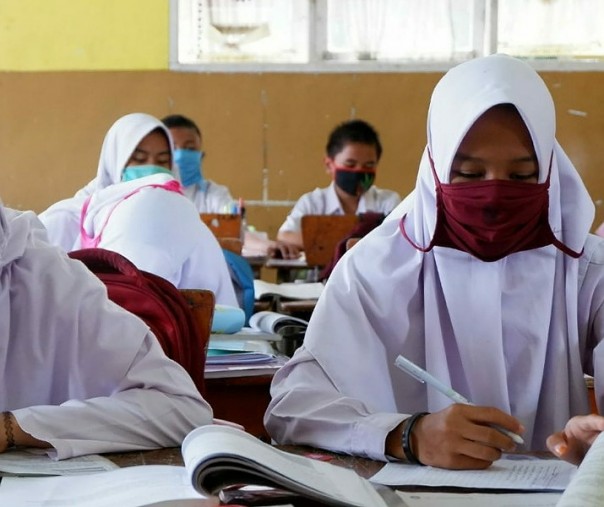 Murid di SDN 105 Tobek Godang di Kecamatan Tampan menggunakan masker saat aktivitas belajar mengajar pada 5 Agustus 2019. Foto: Riau24.