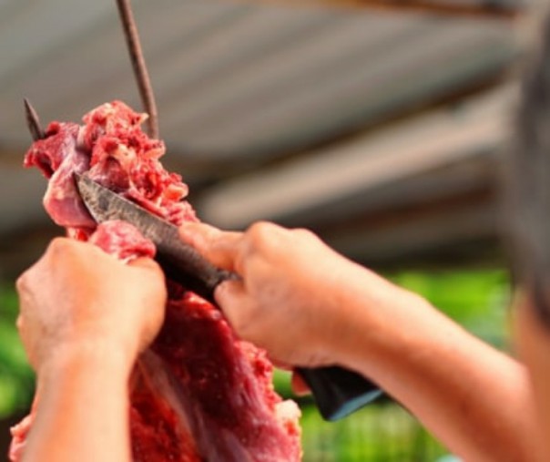 Ilustrasi pria memotong daging kurban. Foto: Shutterstock.
