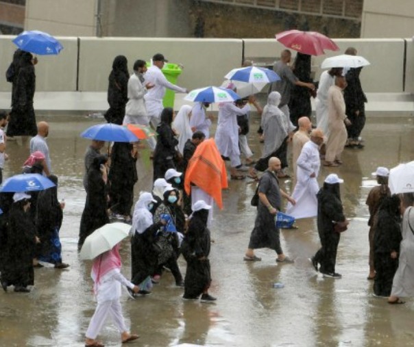 Para jemaah tiba di Mina di bawah hujan lebat untuk melaksanakan lempar jumrah, Makkah, Senin (12/8/2019). Foto: AFP.