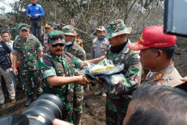 Panglima TNI, Jenderal Hadi Tjahjanto saat menyerahkan seragam baru dan perlengkapan pemadaman kepada salah satu anggota TNI di lokasi karlahut Kecamatan Langgam Pelalawan (foto: dok/riau24group)