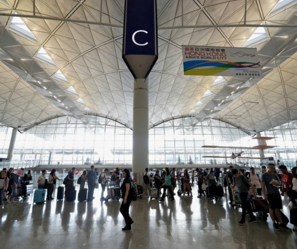 Penumpang mengantri saat bandara dibuka kembali sehari setelah aktivitas penerbangan dihentikan akibat protes, di Bandara Internasional Hong Kong, China, Selasa (13/8/2019). Foto: Reuters.
