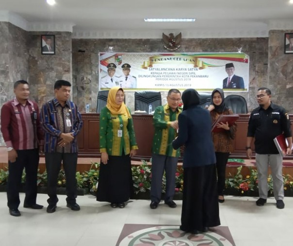 Asisten III Sekretariat Daerah Kota Pekanbaru Baharuddin saat menyematkan tanda jasa kepada 121 PNS di aula Bappeda, Kamis (15/8/2019). Foto: Istimewa.
