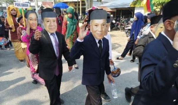 Tampak peserta pawai mengenakan topeng wajah SBY dan Habibie