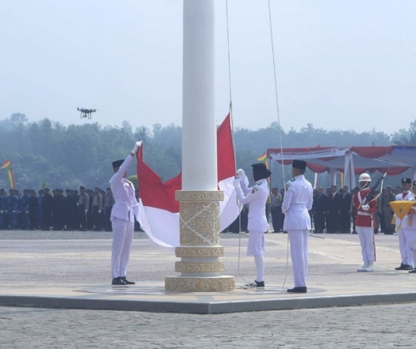 Momen saat pengibaran bendera Merah Putih yang sempat tersangkut di tali. Foto: Surya/Riau1.