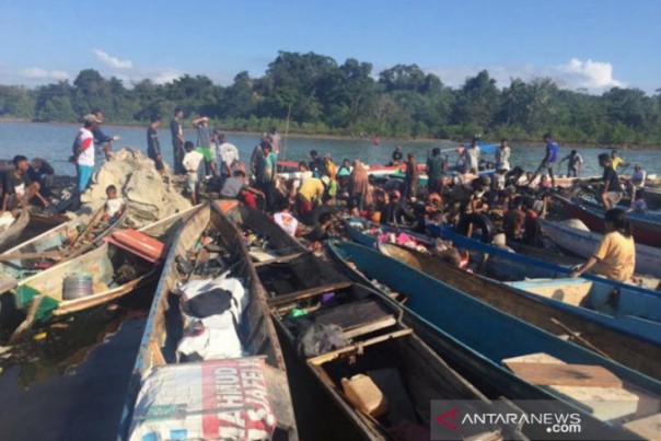 Warga dan petugas mengevakuasi barang barang yang tidak terbakar dari KM Izhar, Sabtu di Konawe, Sulawesi Tenggara. 