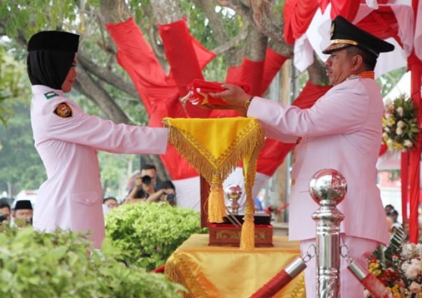 Bupati Siak, Alfedri menerima bendera merah putih saat upacara penurunan bendera