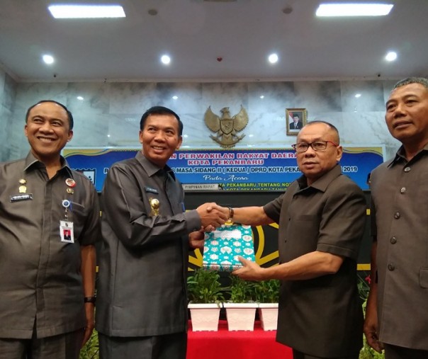 Wali Kota Pekanbaru Firdaus (dua dari kiri) menyerahkan rancangan APBD-P 2019 kepada Ketua DPRD Pekabaru Syahril, Senin (19/8/2019). Foto: Surya/Riau1.