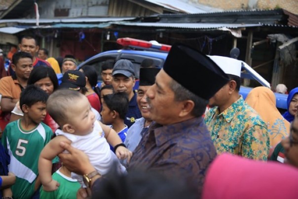 Bupati Siak, Alfedri saat menggendong anak dari korban kebakaran Pasar Sungai Apit