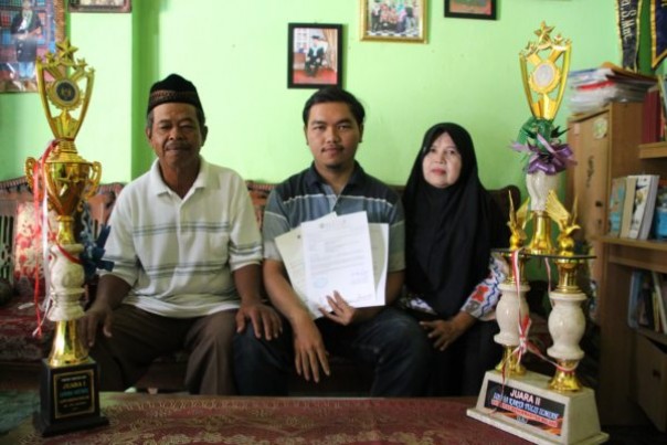 Andreas Rony Wijaya memperlihatkan surat beasiswa dari Taiwan didampingi kedua orang tuanya.