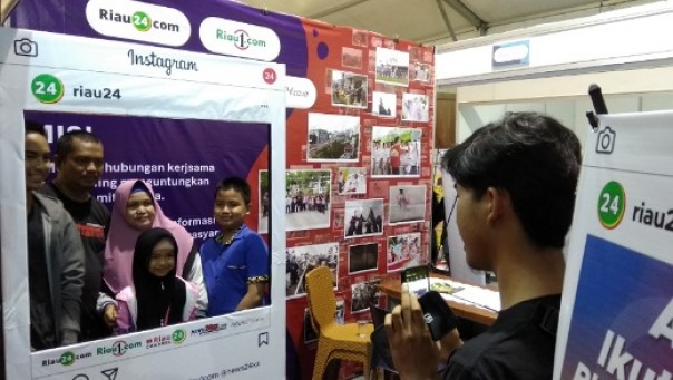 Pengunjung Riau Expo 2019 mengikuti lomba Photo Booth Riau24 di stand Riau24 Group (foto: barkah/riau1.com)