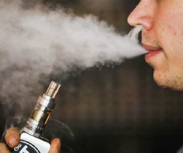 Seorang pria merokok vaporizer elektronik, juga dikenal sebagai e-cigarette atau vape. Foto: Reuters.