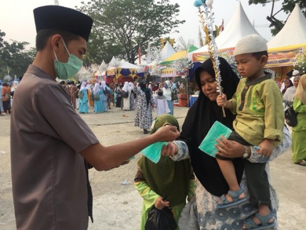 Panitia memberikan masker kepada masyarakat yang mengikuti Gema Muharram di Kabupaten Inhil