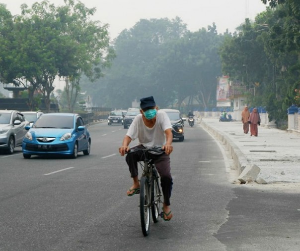 Buruknya kualitas udara di Pekanbaru akibat kabut asap membuat warga harus mengenakan masker saat beraktivitas di luar ruangan. Foto: Riau1.