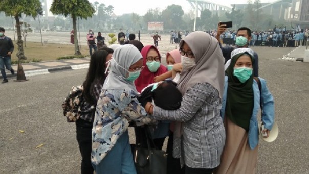 Seorang mahasiswi dievakuasi ke masjid dekat Kantor Gubernur Riau karena pingsan saat aksi menuntut pemerintah menyelesaikan kasus kabut asap di Riau (foto: barkah/riau1.com)