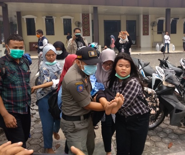 Mahasiswi tumbang saat aksi unras di halaman kantor Gubernur Riau (Foto: Zar/Riau1.com)