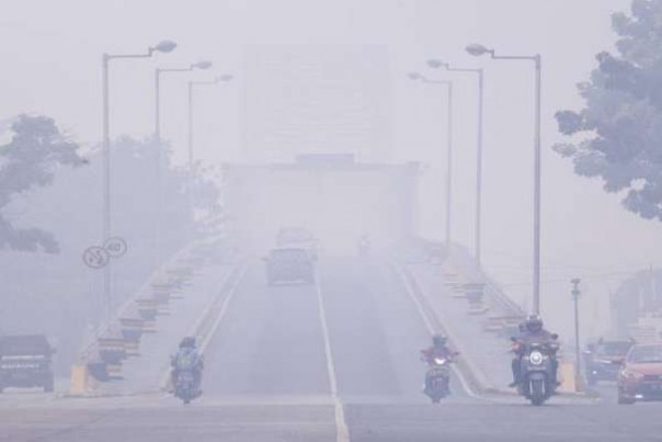 Jembatan Kahayan di Palangkaraya, mulai tidak jelas terlihat akibat kabut asap, Minggu.