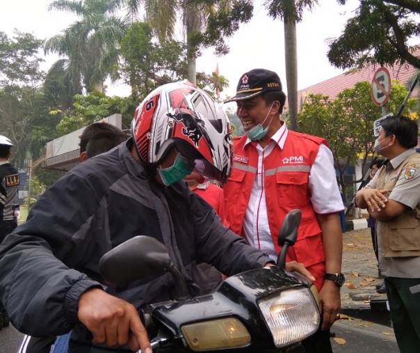 Sekdako Pekanbaru saat membagikan masker kepada para pengendara di Jalan Jenderal Sudirman, tepatnya di depan Mal Pelayanan Publik, Selasa (17/9/2019). Foto: Surya/Riau1.