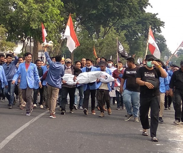 Ribuan mahasiswa UIN Suska Riau membawa pocong mainan dengan foto wajah Gubernur Riau Syamsuar. Foto: Surya/Riau1.