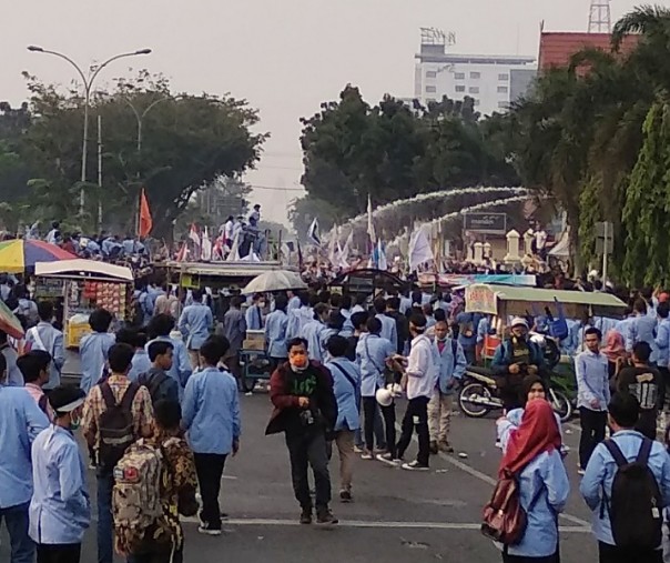 Mobil water canon menyemprotkan air ke arah mahasiswa UNRI, Selasa (17/9/2019). Foto: Surya/Riau1.