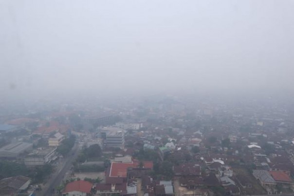 Kota Pekanbaru, Provinsi Riau terlihat dari atas masih diselimuti kabut asap tebal akibat kebakaran hutan dan lahan, Selasa. 