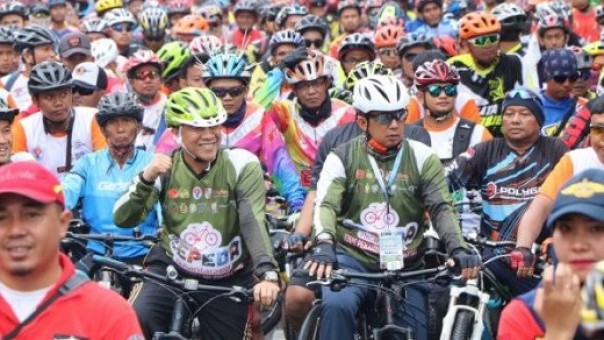 Kepala Dispora Kota Pekanbaru, Zulfahmi Adrian (kaos hijau) bersama Sekdako Pekanbaru, M Noer (kaos hijau) saat event Sepeda Nusantara 2018 lalu di Pekanbaru