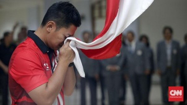 Raja Sapta Oktohari mencium Bendera Merah Putih dengan rasa  haru. 