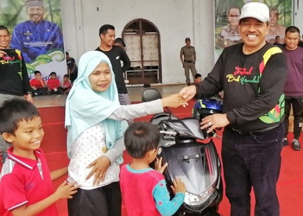 Bupati Siak, Alfedri menyerahkan hadiah satu sepeda motor kepada pemenang undian Jalan Santai HUT ke-20 Siak