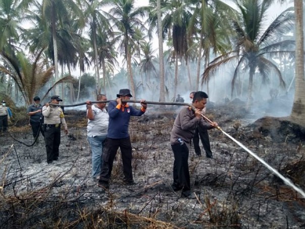 Kapolres Inhil melakukan pemadaman api di lahan warga yang terbakar