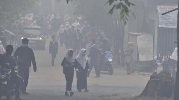 Tampak anak SMP pulang cepat karena kabut asap semakin tebal di Palembang, Senin. 