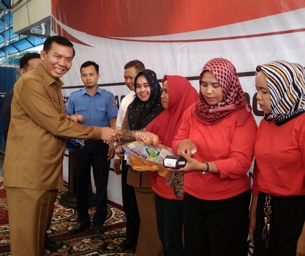 Wali Kota Pekanbaru Firdaus menyalurkan bantuan pangan dari Kemensos kepada Keluarga Penerima Manfaat, Senin (14/10/2019). Di sebelahnya, PKM sedang menggunakan uang elektronik. Foto: Surya/Riau1.